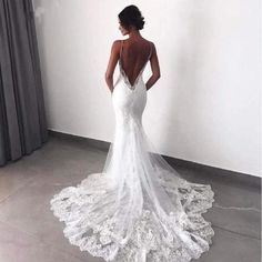 the back of a woman's wedding dress, with an open back and lace detailing