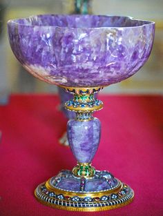 a purple glass bowl sitting on top of a table