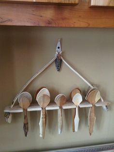 wooden spoons hanging from hooks on a wall