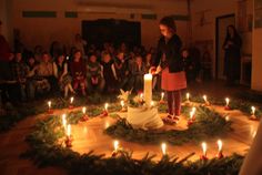 a person standing in front of a cake with candles