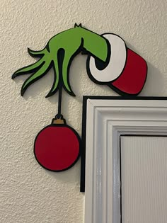 the grin face is hanging on the wall next to a door with a red ornament