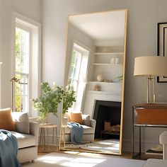 a living room filled with furniture and a large mirror on top of a floor next to a fire place