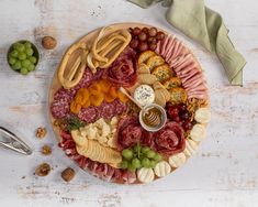 a platter filled with meats, cheeses and crackers