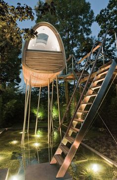 a tree house with stairs leading up to the upper floor and above it is a bed