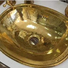 a gold sink sitting on top of a white counter