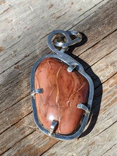 This is a red jasper cabochon in sterling silver. This stone was locally sourced in the north part of Bartow County on Two Run Creek. The stone had a brilliant red color against the surrounding stones which made me pick it up. Jasper is typically a hard stone so I knew it would take a high polish. The finished shape is the general shape of the stone when it was found. The red jasper cab is displayed in a heavy prong set sterling silver frame. The pendant has a large bail to accommodate a beaded Unique Untreated Sterling Silver Gemstones, Artisan Sterling Silver Gemstone, Artisan Sterling Silver Gemstones With Large Stone, Untreated Red Sterling Silver Jewelry, Red Jasper Necklace, Sterling Silver Gemstone Necklace, Teardrop Ring, Montana Agate, Jasper Necklace