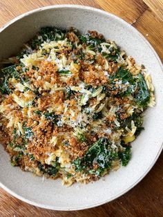 a white bowl filled with food on top of a wooden table