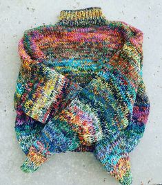 a multicolored sweater laying on the ground