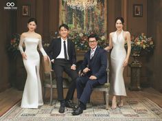 two men and three women posing for a photo in front of a chandelier