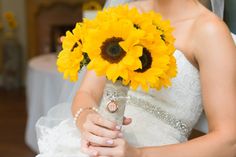 a bride holding a bouquet of sunflowers at her wedding day in front of the camera