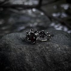 Embrace the enchanting design of this garnet orchid ring, featuring intricate flower details ✨  and a touch of victorian flair. 🥀 ♥️  This alluring piece blends gothic allure with romantic Victorian charm, making it the perfect adornment for those who wish to add a touch of dark beauty into their everyday style.  🕯️   The unique combination of Victorian and whimsigoth elements makes this ring a versatile accessory, complementing a variety of styles making it a great gift for loved ones or a un Orchid Ring, Emo Gifts, Gothic Wedding Rings, Witchy Gifts, Dark Romantic, Ring Flower, Gem Ring, Charm Making, Garnet Stone