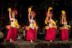 three women in red and yellow costumes on stage