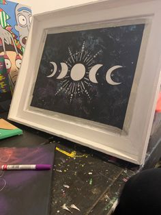 an art work with three phases of the moon on it and some crayons