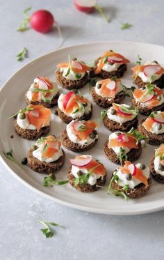 a white plate topped with mini cakes covered in cream cheese and vegtables