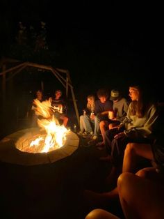 a group of people sitting around a fire pit