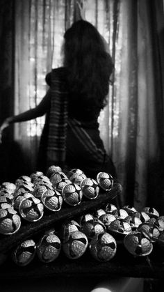 a woman standing in front of a table filled with pastries