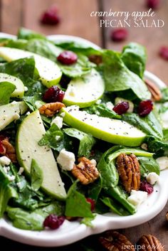 a salad with apples, cranberries and pecans in it on a plate