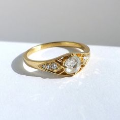 a close up of a gold ring with diamonds on the bottom and an oval shaped diamond in the middle