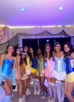 a group of young women standing next to each other in front of a room filled with lights