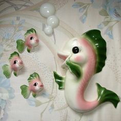 a group of seahorse figurines sitting on top of a bed next to balloons