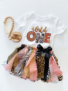 Adorable wild one first birthday party outfit.  Bodysuit with cute wild one design printed on the front.  Adorable coordinating handmade tutu with matching fabrics, ribbons and trim, ribbon bow at waist on sewn elastic band for flexible comfort. She's A Wild One Birthday Party, Shes A Wild One Birthday, Wild 1 Birthday Party, Wild 1 Birthday, Wild One Birthday Outfit, 1 Birthday Party, Safari Theme Birthday Party, Wild One 1st Birthday, 1st Birthday Outfit Girl