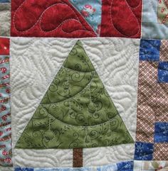 a quilted wall hanging with a christmas tree on it