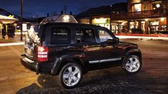 a black suv parked in front of a building at night