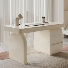 a white desk with two lamps on it in front of a curtained window and rug