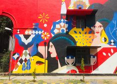 a large colorful building painted on the side of it's face and two women