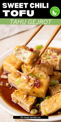 tofu is being served with chopsticks in a white bowl on a table