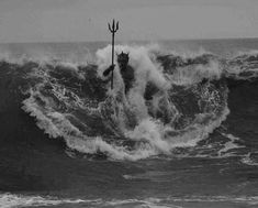 a person on a surfboard in the middle of a wave with two poles sticking out of it