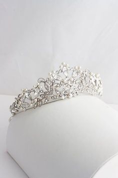 a tiara with pearls on it sitting on a table