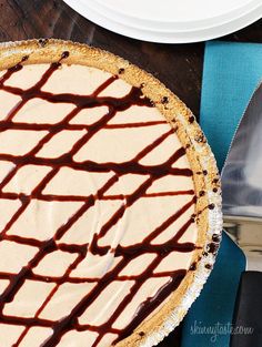 a chocolate covered pie sitting on top of a table next to a knife and fork