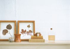 two framed pictures sitting on top of a mantle