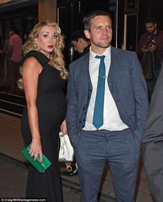 a man in a suit and tie standing next to a woman wearing a black dress