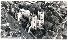 an aerial view of a large church in the middle of a small town with tall buildings