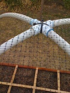 an airplane made out of plastic sitting on top of a field next to a fence