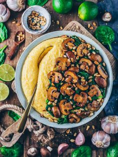 a white bowl filled with mushrooms and spinach on top of a wooden cutting board