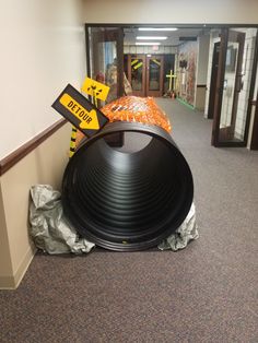 a large black object sitting on top of a pile of trash in an office hallway