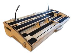 a musical instrument case that is made out of wood and has black stripes on it