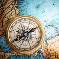 a compass on top of a map with focus on the middle part of the world