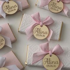 pink and white wedding favors with name tags on them, tied in twine ribbons