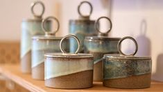 four canisters with rings on them sitting on a shelf