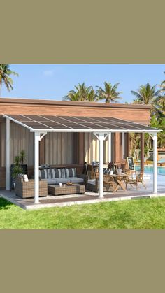 an outdoor living area with couches and tables next to a pool surrounded by palm trees