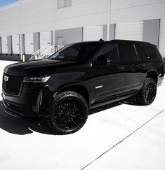 a black suv parked in front of a building