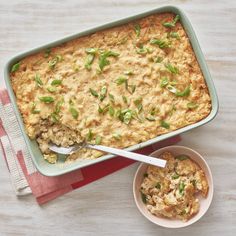 a casserole dish filled with rice and topped with chopped green onions next to a small bowl