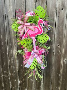 a pink flamingo wreath on a wooden fence