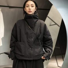 Looking for a stylish and warm coat to keep you cozy this winter? Look no further than our Techwear Fashion Parka! Made with black cotton-padded fabric, this coat is perfect for keeping you warm in cold weather. With a short stand collar and long sleeves, this coat is both stylish and functional. The loose fit also ensures that you will be able to move around comfortably in cold weather. So whether you are running errands or going out on the town, our Techwear Fashion Parka will keep you warm an Solid Funnel Neck Outerwear For Work, Winter Techwear Outerwear With Stand Collar, Winter Techwear With Stand Collar, Fall Outerwear With Detachable Hood And Stand Collar, Winter Urban Outerwear With Stand Collar, Modern Outerwear With Stand Collar For Winter, Black Funnel Neck Outerwear For Winter, Modern Outerwear For Cold Weather And Winter, Modern Winter Outerwear With Padded Collar