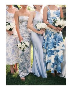 the bridesmaids are all dressed in blue and white dresses with flowers on their bouquets