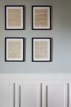 three framed music manuscripts hang on the wall